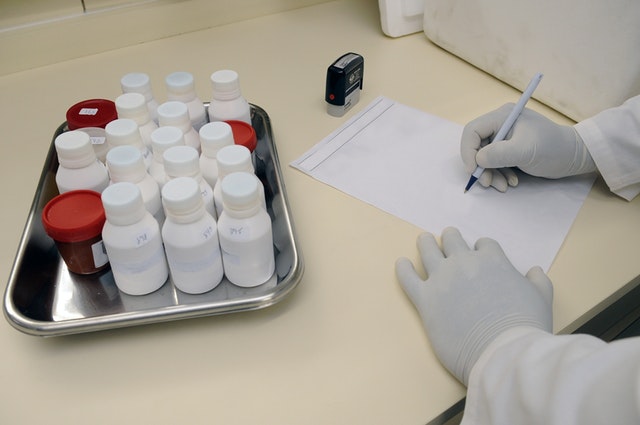 法医毒物検査 薬品の瓶と手袋をした手